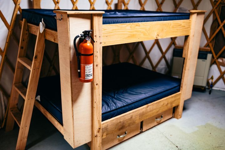 a small wooden bed sitting in a chair