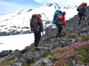 Three hikers going up mountain side