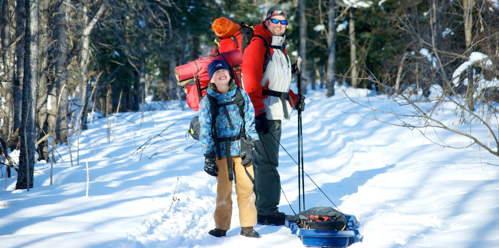 Father and sun hiking in snow