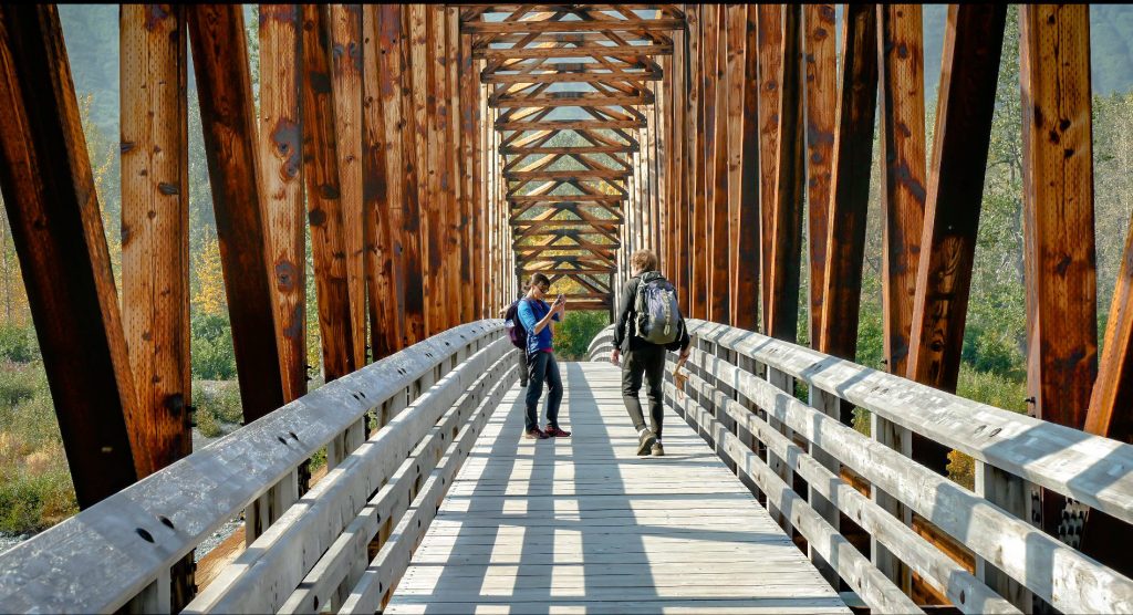 a wooden bench sitting next to a fence