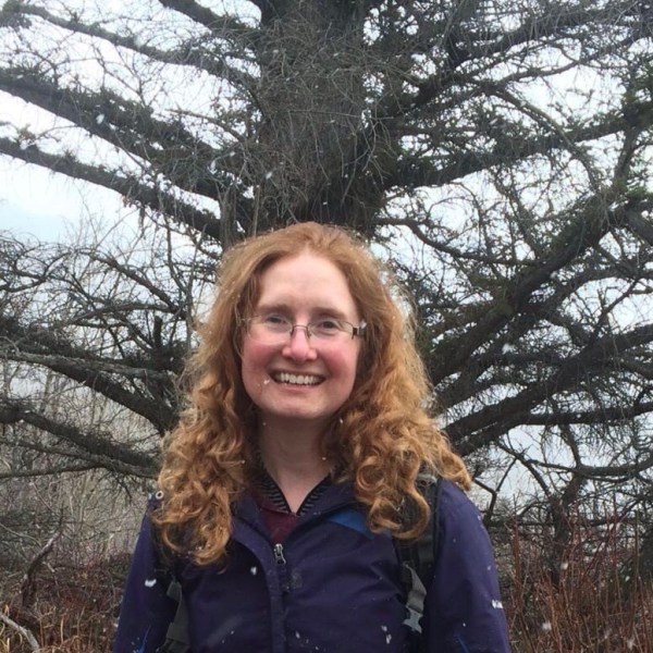 a person posing in front of a tree