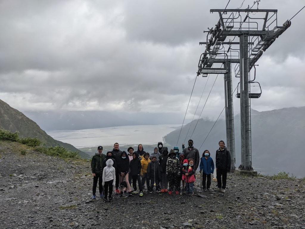 a group of people standing on top of a hill