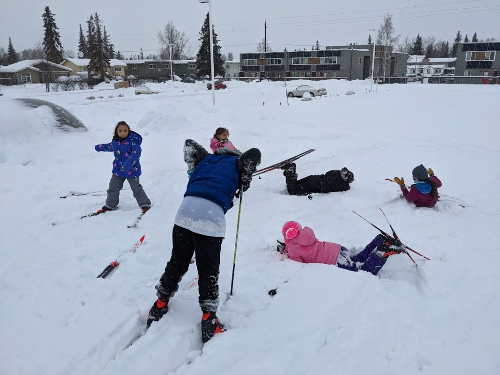 a group of people riding skis down a snow covered slope