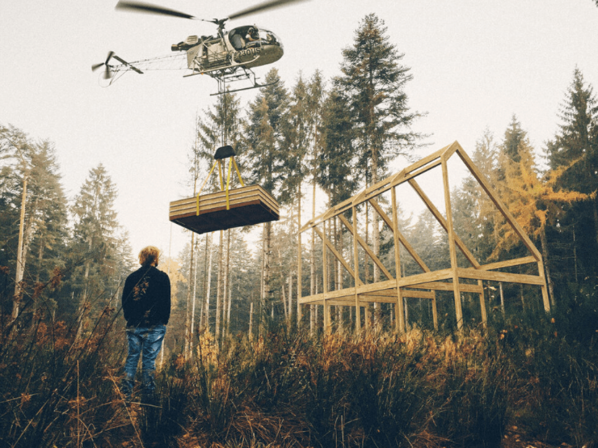 a man flying a kite in a forest