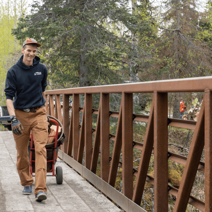 a man sitting on a bench next to a fence